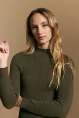 Polera de punto acanalado color gris, con cuello alto y mangas largas, de calce ajustado al cuerpo.