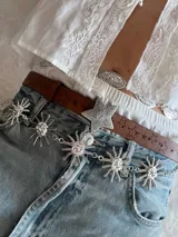 Cinturón marrón de cuero sintético con estrellas grabadas y hebilla plateada en forma de estrella.