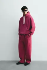 Pantalón jogger relaxed fit color bordó, confeccionado en tejido con algodón e interior forrado en tejido polar. Cuenta con cintura elástica, bolsillos frontales, bolsillos traseros de vivo y detalle de costura frontal en las perneras.