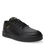 Championes Puma Court Classic de cuero sintético color negro, con detalles dorados en el logo y cordones negros.