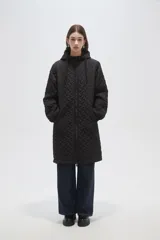 Campera larga de diseño acolchado con patrón geométrico, color negro. Cuenta con capucha ajustable, cierre frontal completo y bolsillos laterales.