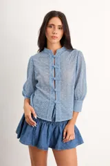 Camisa de algodón bordado color crudo, con cuello mao, manga 3/4 y cierre frontal con broches de estilo oriental.