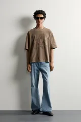 Remera relaxed fit color marrón con cuello redondo, manga corta y parche bordado a tono con letras en el frente.
