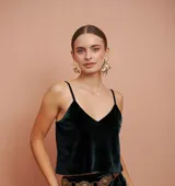 Top verde oscuro de terciopelo con breteles finos y escote en V. Presenta una flor bordada en la espalda.