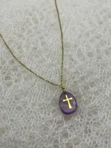 Collar con cadena dorada y dije de piedra natural pulida con cruz dorada incrustada. Disponible en tres colores: rosa, lila y blanco.