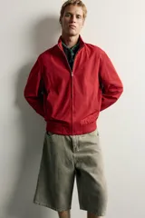 Cazadora relaxed fit de tejido ligero color azul marino, con cuello subido, manga larga y cierre frontal de cremallera. Cuenta con bolsillos frontales de vivo en la cadera y acabados en rib elástico en puños y cintura.