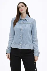 Campera de jean en tono celeste claro, con diseño de frunces en la parte superior delantera, mangas largas con puños ajustados y cierre frontal mediante botones metálicos.