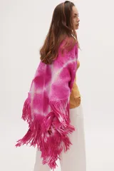Chaleco tejido de punto fucsia con estampado tie-dye blanco y flecos en el ruedo.