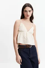 Musculosa de tiras finas color crema, con escote en V y vuelo en la base.