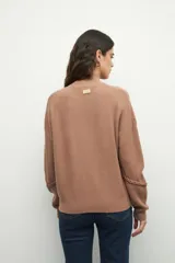 Polera tejida color borgoña, de cuello alto y mangas largas abullonadas con detalle de bordado trenzado en los puños.