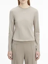 Remera gris de algodón regenerativo, corte slim, cuello redondo y manga larga. Logo pequeño de Calvin Klein debajo del cuello.