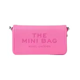 Minibandolera de cuero color rosa vibrante con textura granulada. Presenta la inscripción "THE MINI BAG" y "MARC JACOBS" en relieve en el frente. Incluye correa fina metálica para llevar al hombro o cruzada.
