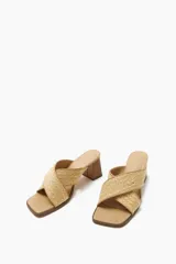 Sandalia color beige con tiras cruzadas de rafia y taco cuadrado de madera.