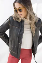 Campera tipo gamulán de cuero genuino color negro, con interior y cuello de piel sintética en tono grisáceo. Presenta cierre frontal, costuras visibles y diseño estructurado.