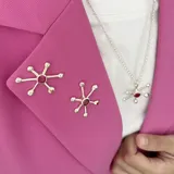 Set de prendedores y collar plateados con forma de estrella de mar con centro de piedra roja.