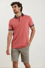 Remera tipo polo color salmón jaspeado, con cuello y puños en contraste azul marino con ribete blanco.
