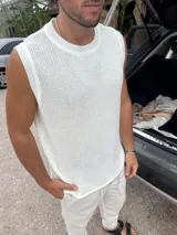 Musculosa de punto color blanco, con cuello redondo y sisas amplias.