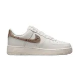 Championes Nike Air Force 1 de corte bajo, color blanco con detalles en textura de piel de serpiente en tono bronce en el swoosh lateral y en el talón.