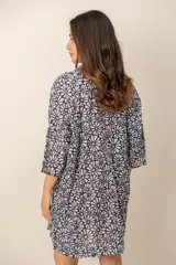 Vestido corto camisero con estampado de rayas multicolores, cuello camisero, mangas tres cuartos y cierre frontal de botones.