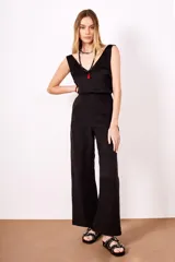 Pantalón negro de tiro alto, corte ancho y pierna ancha, sin pinzas visibles.