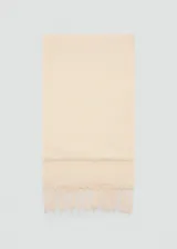 Fular color beige de textura gofrada con terminación de flecos en los extremos.