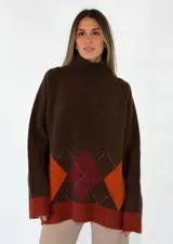 Sweater de cuello alto con diseño de rombos en tonos grises y detalles en rojo. Presenta puños y ruedo en tejido acanalado de color gris claro.
