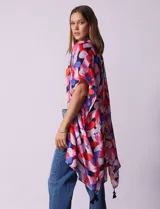 Kimono tejido con estampado floral multicolor y terminación de ruedo con borlas verdes.