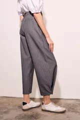 Pantalón gris a rayas verticales blancas, de corte recto y tiro medio.