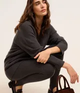 Pantalón legging de punto color gris oscuro, tiro alto, con cintura elástica y cinta estribo para ajuste en el pie.