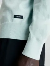 Sweater celeste de punto fino, con cuello redondo y logo de la marca en etiqueta cosida en el lateral.