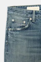Jeans de tiro medio con diseño flare, efecto lavado y detalles de roturas en las piernas. Presenta cinco bolsillos, trabillas para cinturón y bajo deshilachado sin costuras.