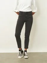 Jean skinny de tiro medio en color negro lavado, con cierre y botón frontal, bolsillos laterales y traseros.