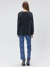 Remera de manga larga MUTMA Sticha, color negro con efecto acid wash y costuras decorativas expuestas en color celeste brillante. Cuenta con corte clásico, cuello redondo a la base y calce holgado.