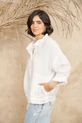 Campera color beige de lino, con cuello mao, mangas 3/4 con botón para sujetar, cierre frontal con botones y ajuste con cordón en la cintura.