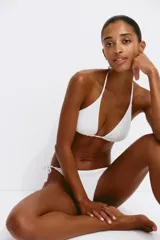 Top de bikini con textura fruncida, color blanco, de diseño triangular con tiras ajustables para atar en el cuello y la espalda.