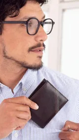 Billetera de cuero marrón oscuro con costuras decorativas en el frente. Interior con visor, tarjeteros y doble compartimento para billetes.