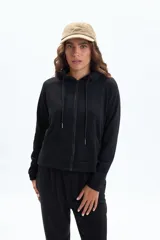 Campera deportiva negra con cierre frontal, capucha con cordones y bolsillos canguro. Presenta un corte ligeramente corto y mangas raglán.