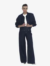 Chaqueta de denim azul oscuro, con cuello camisero, cierre frontal y puños ajustados con elástico. Presenta un calce regular y holgado.