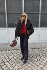 Jersey de punto color rojo vibrante, con cuello barco y manga larga. Presenta un calce amplio estilo capa con bajo asimétrico y aberturas laterales.