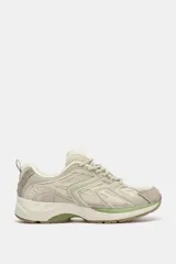Zapatilla deportiva estilo running con combinación de materiales y detalles en tonos verdes. Presenta puntera redonda, tirador trasero y suela con relieve.
