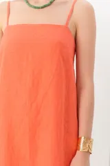 Vestido corto de lino color fucsia, con breteles finos y escote recto.