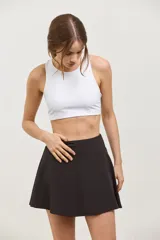 Top deportivo corto de sujeción media, con escote redondo clásico y espalda abierta. Presenta un diseño al cuerpo con elástico interno en la cintura.