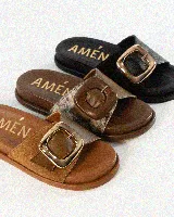 Sandalias de cuero color negro, de diseño plano con una tira ancha en el empeine y una hebilla metálica dorada grande como detalle.