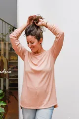 Remerón holgado color salmón, con cuello bote y mangas largas.