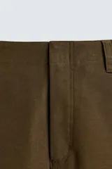 Pantalón de corte balloon fit, color negro, con bolsillos laterales de vivo y bolsillos traseros con solapa. Presenta cierre frontal con cremallera y botón.