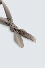 Pañuelo cuadrado de algodón color beige/tostado con doble borde cosido en hilo negro contrastante.