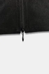 Top de cuello subido y manga corta color negro, con cierre frontal de cremallera y detalle de frunces en los laterales.