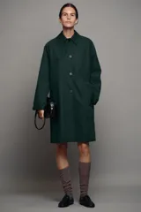 Trench midi ZW Collection verde oscuro con cuello solapa, manga larga, bolsillos laterales en costura y cierre frontal con botones. Cuenta con forro interior a contraste y detalle de solapa corta en el pecho.