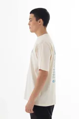 Remera color crudo de algodón con estampado azul de la banda Oasis, con logo, dibujos de los integrantes y referencias a sus canciones.