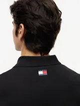 Chomba de algodón elástico con cuello polo y cartera de tres botones. Presenta un diseño de corte regular con cuello y puños de punto canalé, destacando por el logo colaborativo de Tommy Hilfiger y Cadillac Formula 1 en el pecho.